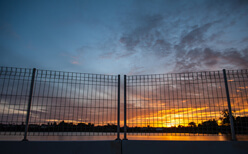 Photo of a durable commercial fence at night.