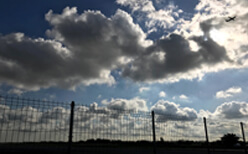 Photo of a durable commercial fence during a storm.