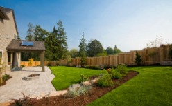 Residential Fencing in Peoria IL alongside a Big Brown House and Grassy Green Yard