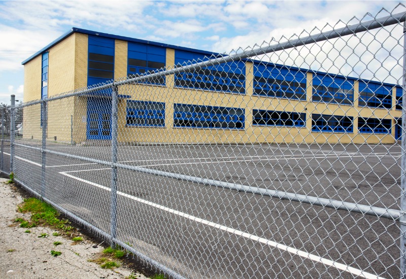 A chain link fence near a school