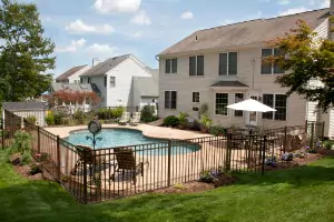 A metal fence is seen around a pool. Hohulin Fence are installers in Springfield IL.